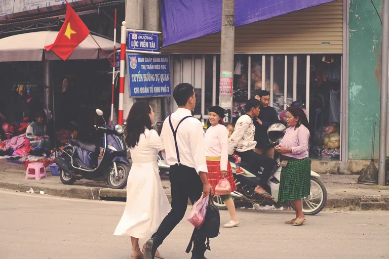 people sitting on bench near road during daytime