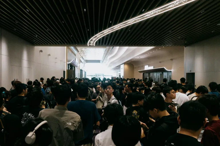 A crowd of people gather in a spacious hall.