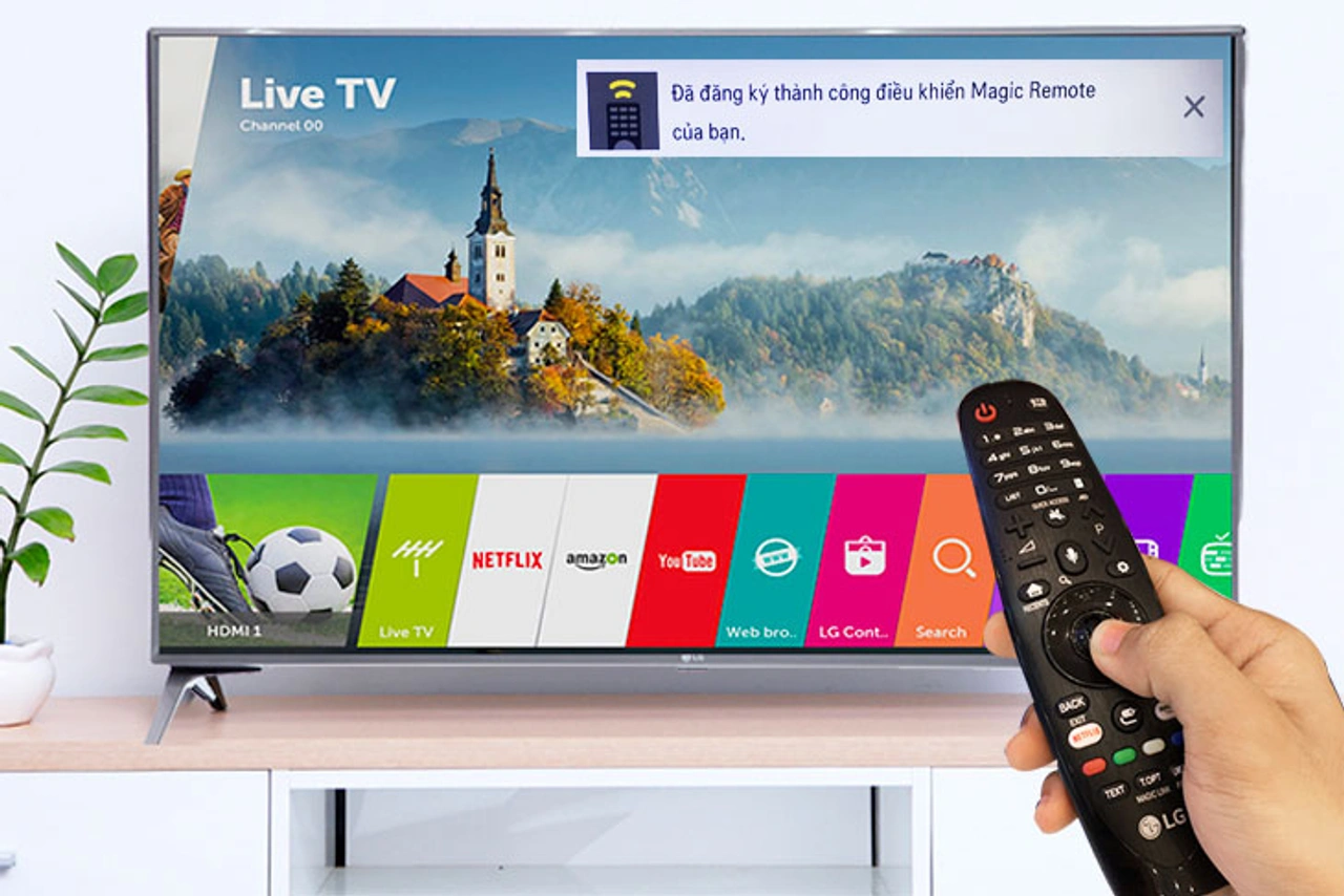 Người dùng dùng remote thông minh LG ra lệnh cho tivi